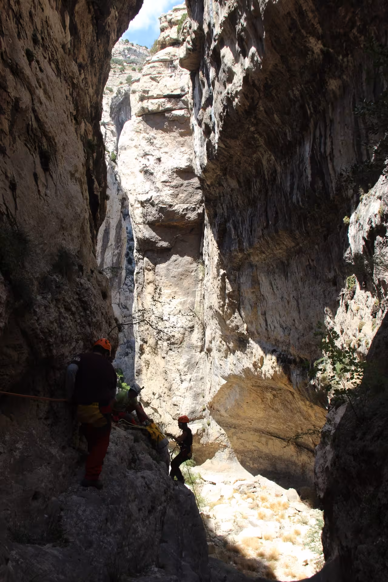 Barranco seco en Aliaga, Teruel, con grupo haciendo rápel entre paredes de roca en cañón estrecho