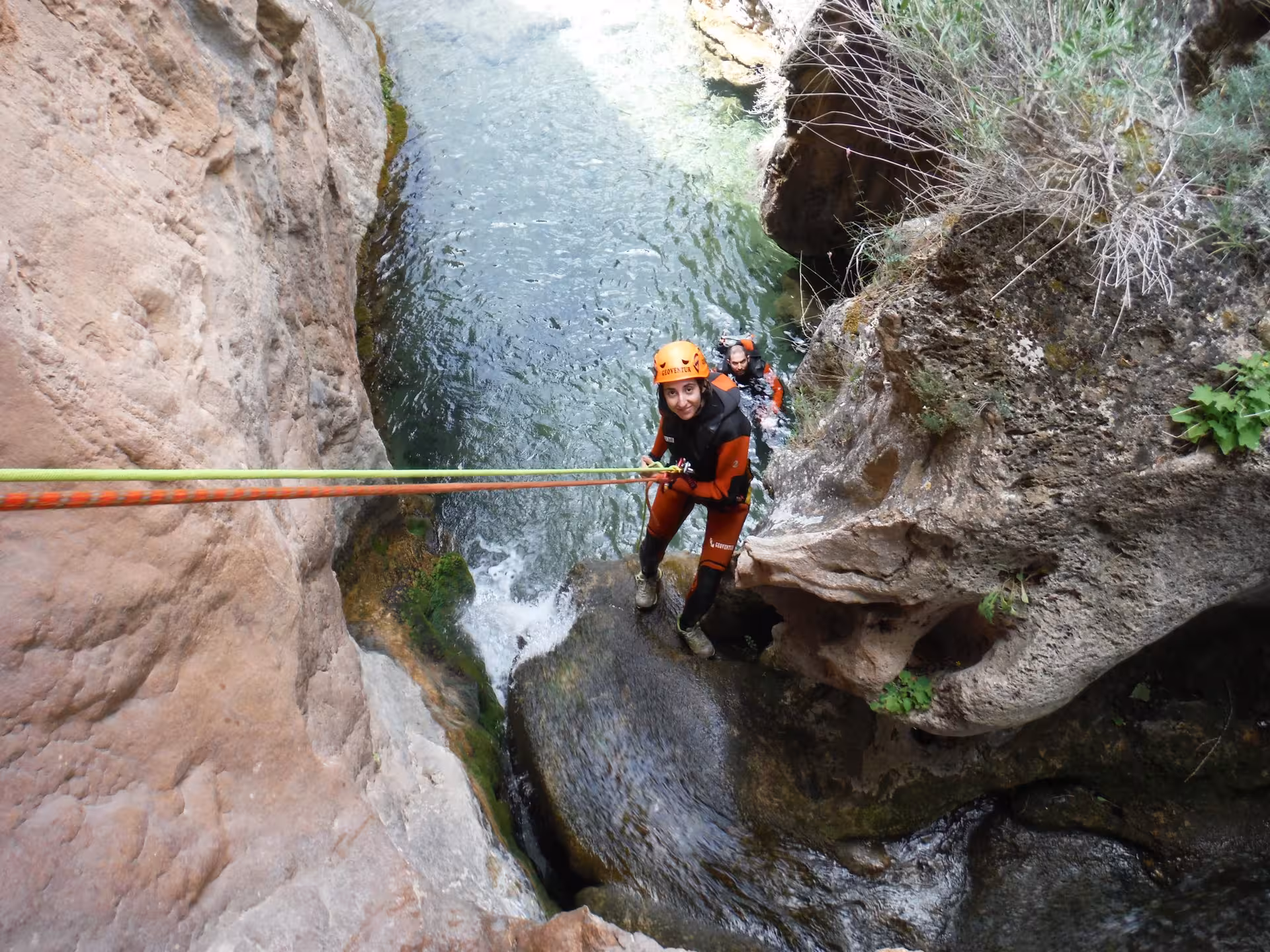 Barranquista desciende con cuerda junto a cascada en el barranco acuático de Riodeva, Teruel, tour guiado