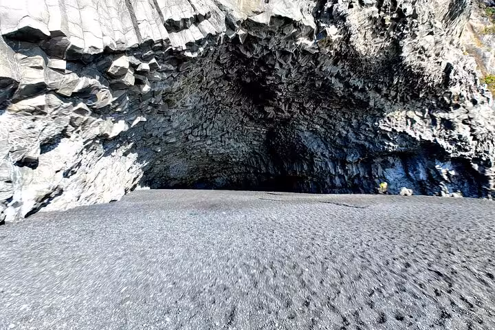 Dark basalt cave entrance on black sand beach near Vik Iceland
