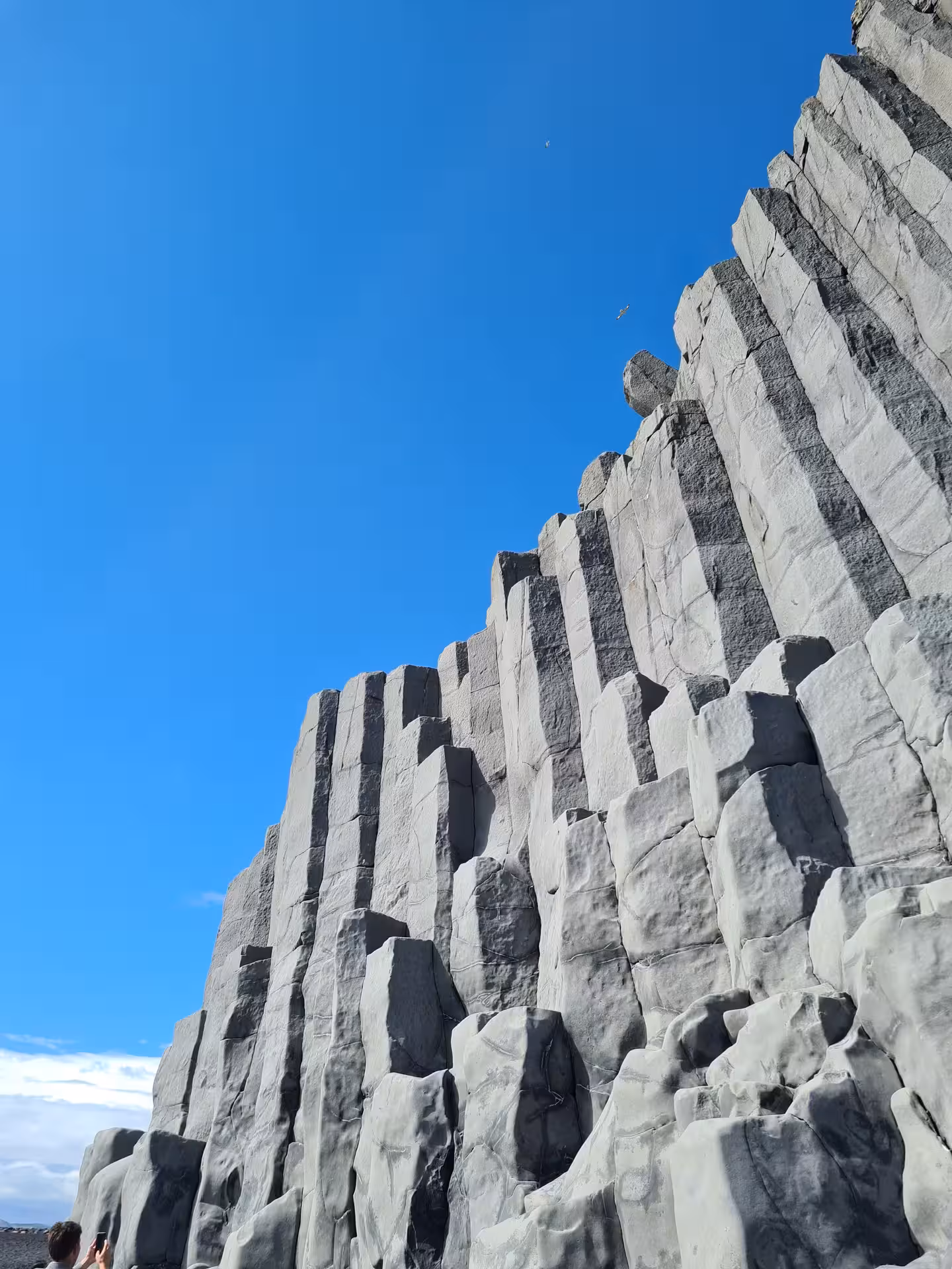 Towering basalt columns at Iceland's South Coast under a clear blue sky