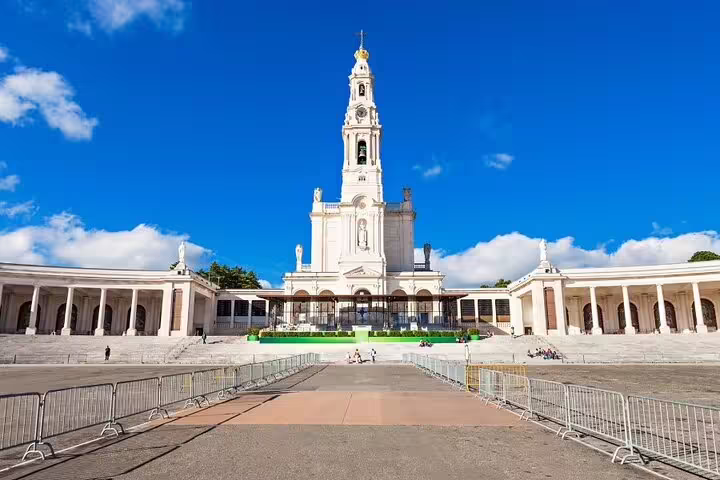 The Basilica of Our Lady of Fátima under a clear blue sky, a highlight of the Fátima, Nazaré, and Óbidos full-day tour.