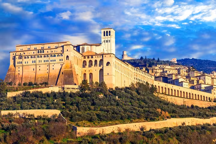 Stunning view of the Basilica of Saint Francis of Assisi under a vibrant sky, a highlight of the Assisi day tour.