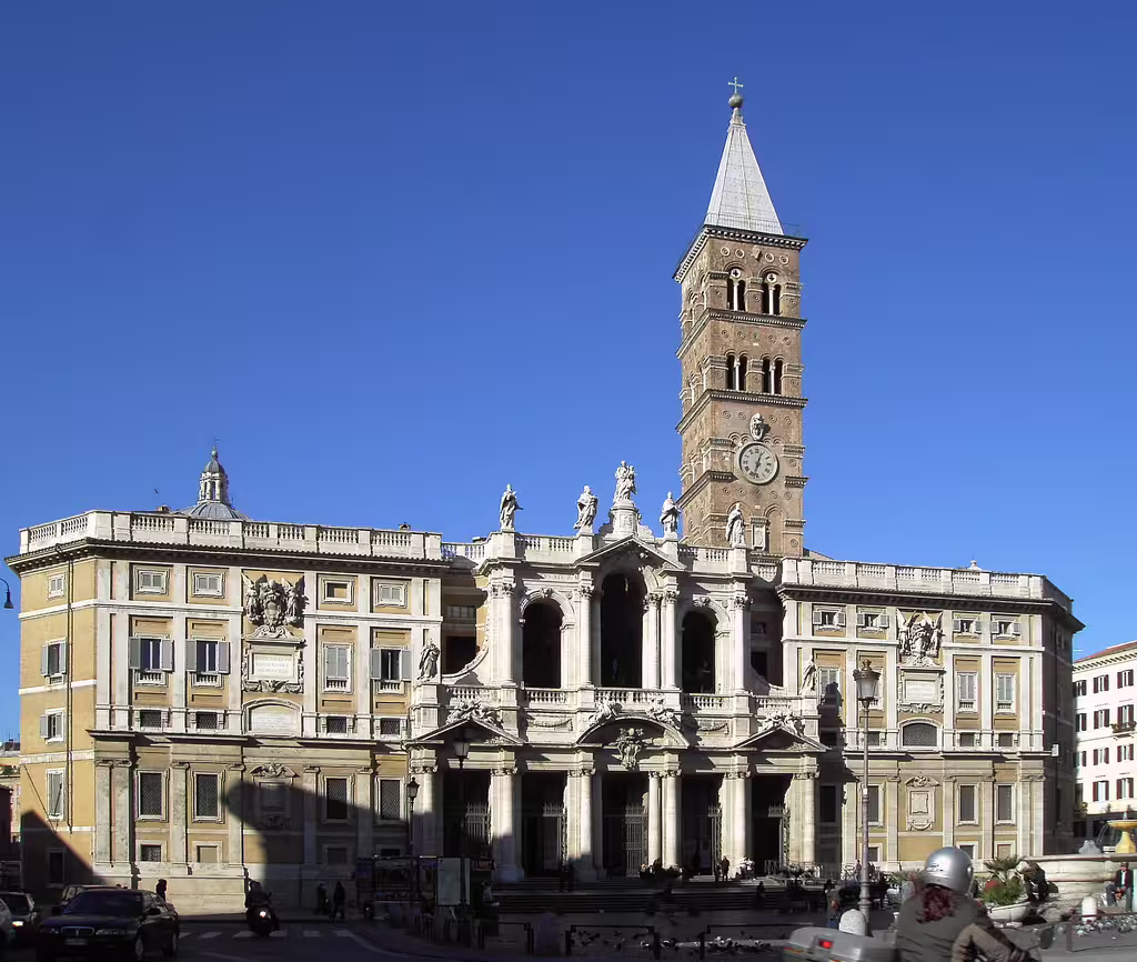 Facade of the Basilica of Santa Maria Maggiore in Rome with bell tower and statues, seen on a clear blue-sky walking tour day