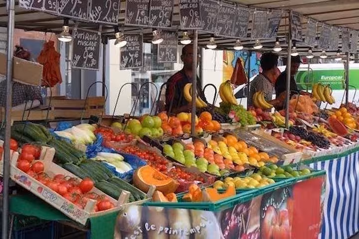 Vibrant fruit and vegetable stall at Bastille Market, showcasing fresh produce on the Paris food tour.