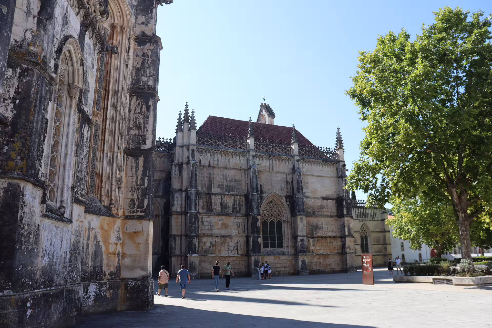 Historic monastery facade in Batalha, Portugal, showcasing Gothic architecture on a sunny day, perfect for cultural tours.