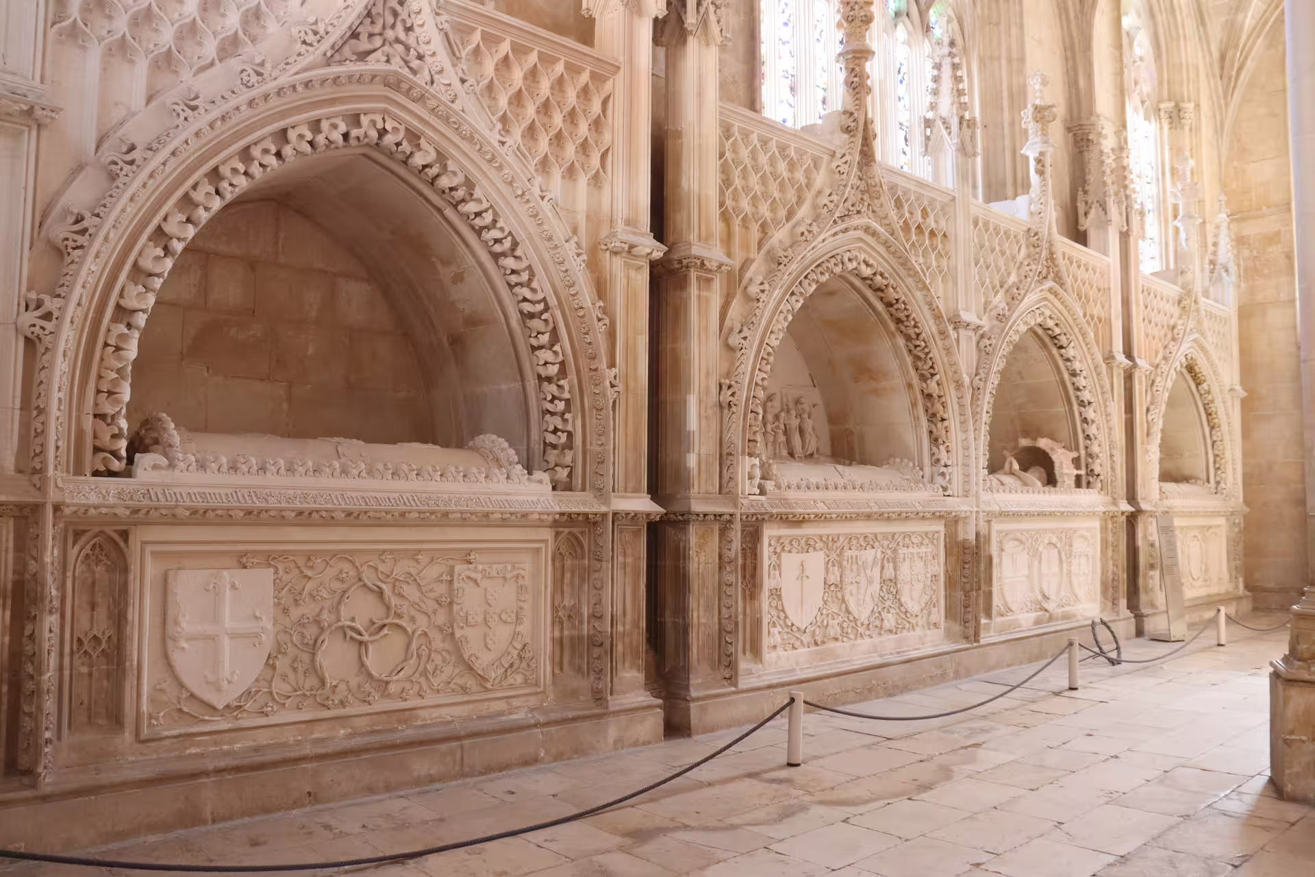 Intricate Gothic architecture inside Batalha Monastery, showcasing historical tombs on a private tour through Tomar, Fátima, and Batalha.