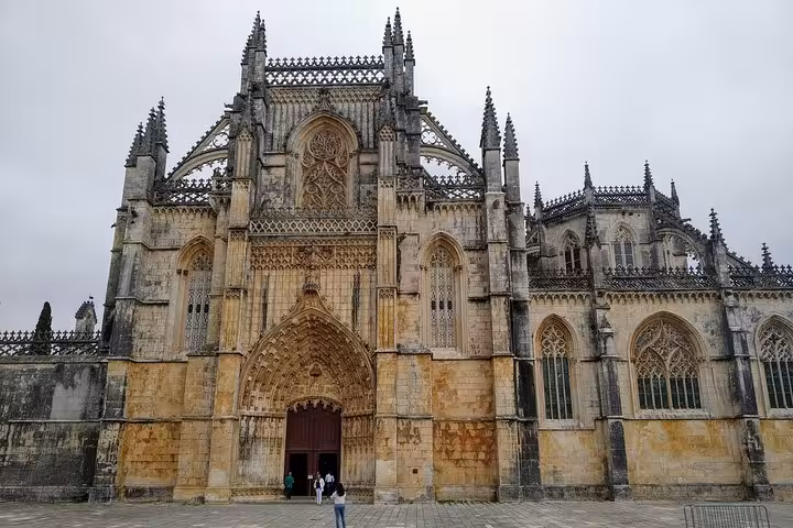 Front facade of Batalha Monastery showcasing its intricate Gothic architecture, ideal for private tours in Portugal.