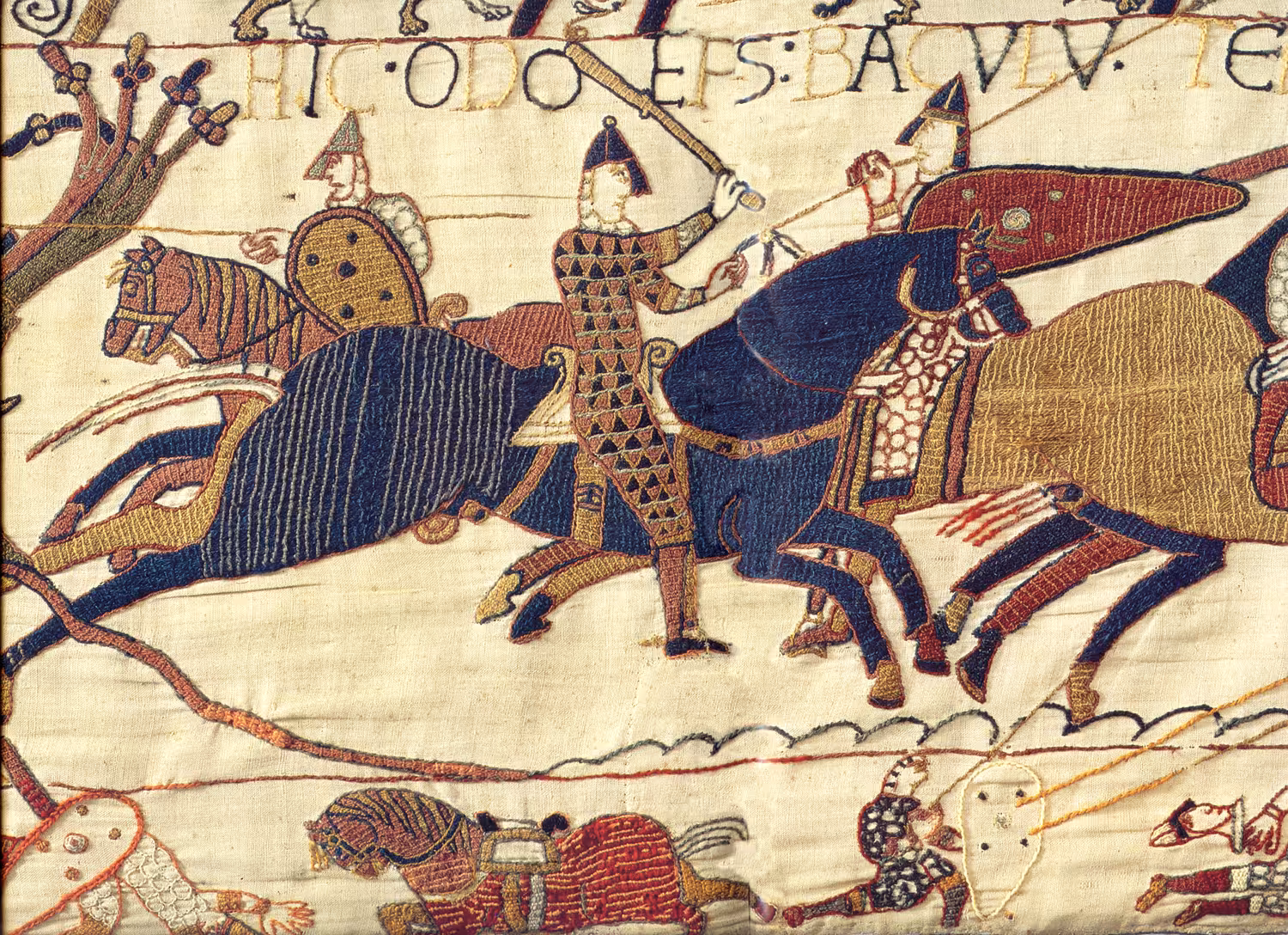 Bayeux Tapestry detail showing Norman knights on horseback in battle, with Latin inscription above