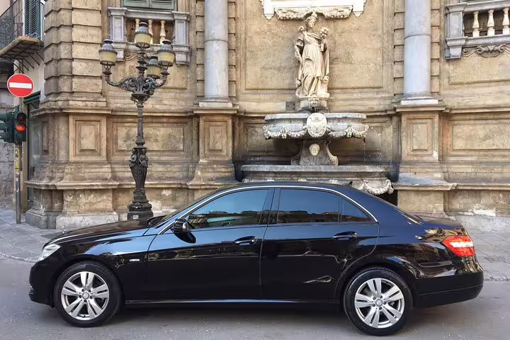 Private black sedan for B&B Hotels Palermo Quattro Canti to Palermo Airport transfer parked by historic Baroque fountain