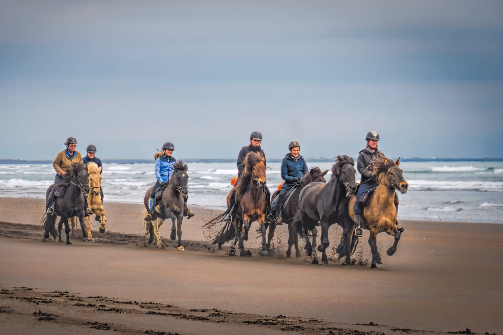Group horseback riding on the shoreline during 06A The Beach Ride, guided coastal tour with ocean waves