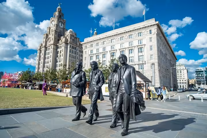 Beatles bronze statues on Liverpool waterfront with Royal Liver Building in background
