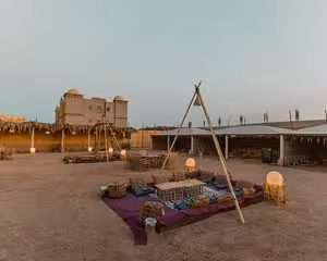 Traditional Bedouin camp setup with colorful cushions and tripod in desert at dusk, Marsa Alam