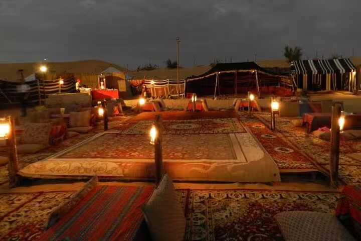 Night Bedouin camp in Sharm El Sheikh with lantern-lit carpets and seating for desert dinner show experience