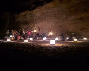 Tourists dining inside a cave with glowing lanterns at a Bedouin camp in Marsa Alam