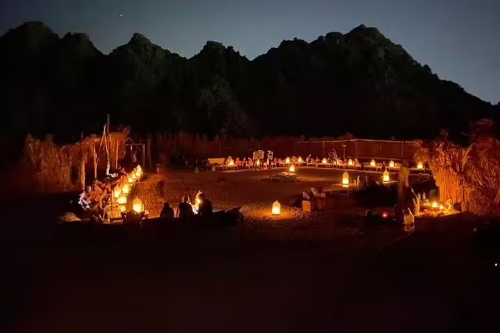 Bedouin desert dinner show in Sharm El Sheikh with lantern-lit campfire seating under Sinai mountains at night