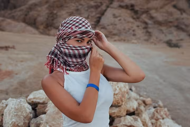 Traveler wearing Bedouin scarf in Hurghada desert on Jeep safari adventure, ready for Bedouin dinner and stargazing