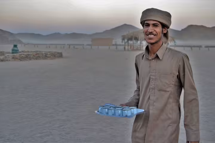 Bedouin host serving tea in the desert on Hurghada stargazing adventure by jeep with optional ATV quad safari