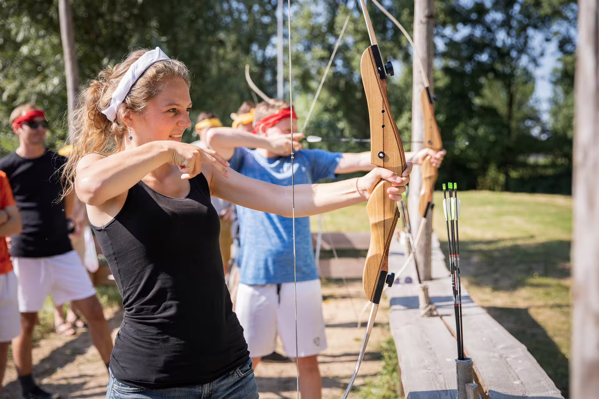 Beginner archery lesson in Amsterdam with instructor guidance as a woman draws a recurve bow at the range