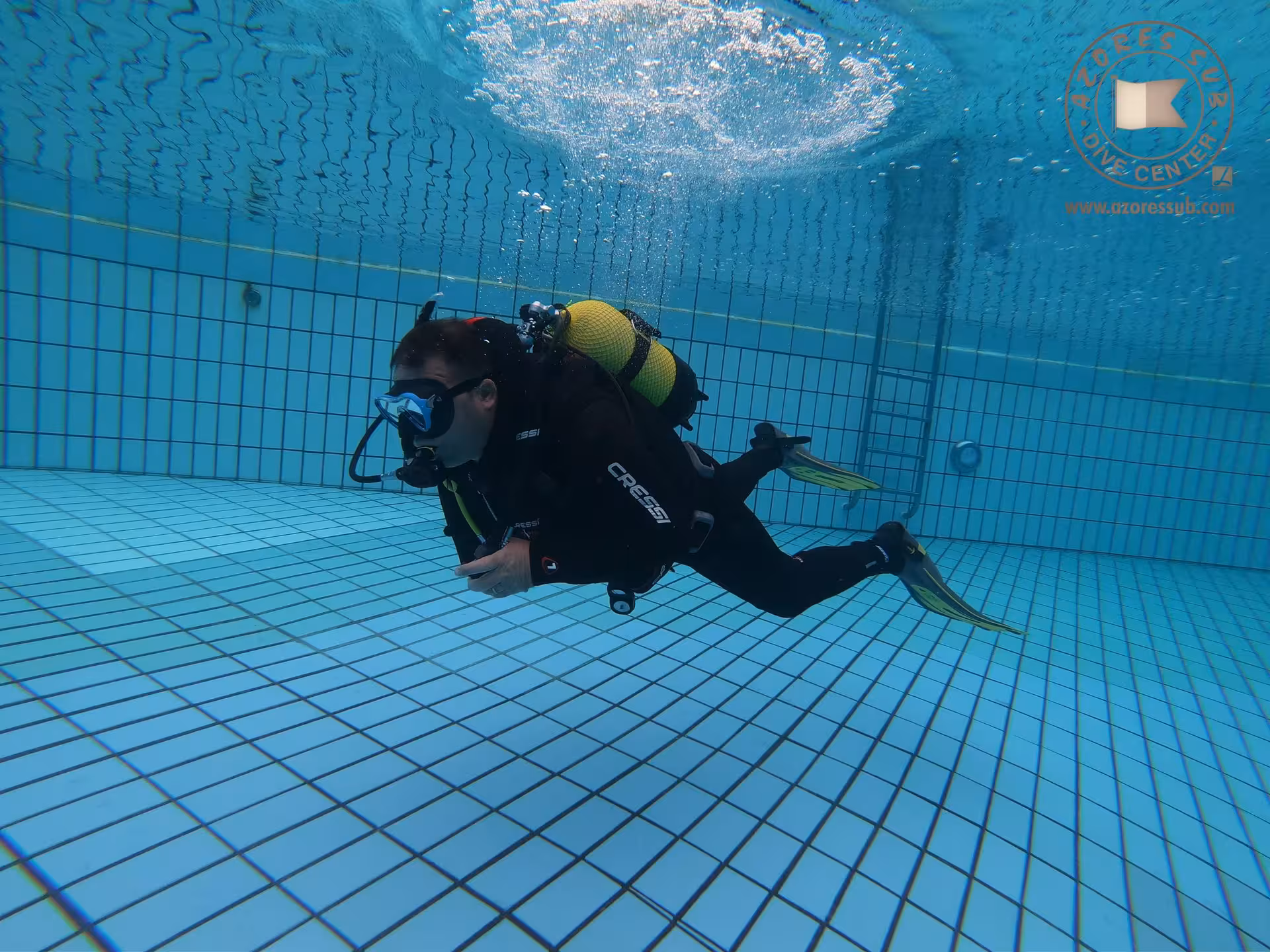 Beginner scuba diver swimming underwater in a pool with full gear, baptism in a swimming pool training experience