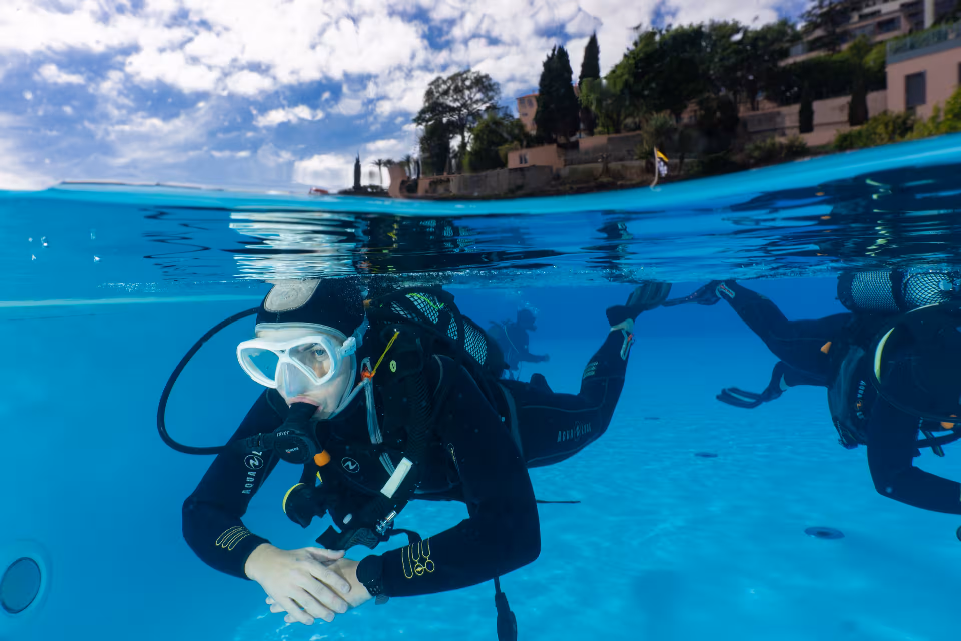 Diver floating near the surface in a serene pool setting, great for initial scuba diving experience.