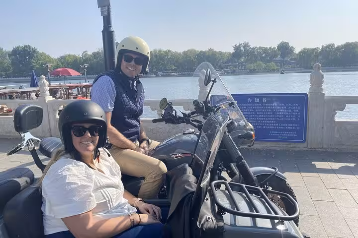 Tourists enjoy a scenic ride by a Beijing lakeside on a private sidecar tour, capturing the essence of adventure and exploration.
