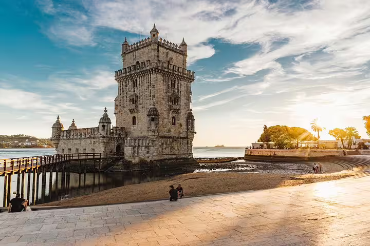 Sunset view of Belém Tower, a historic Lisbon landmark, from a scenic spot on the True 4Hour Private Tuk Tuk Tour.