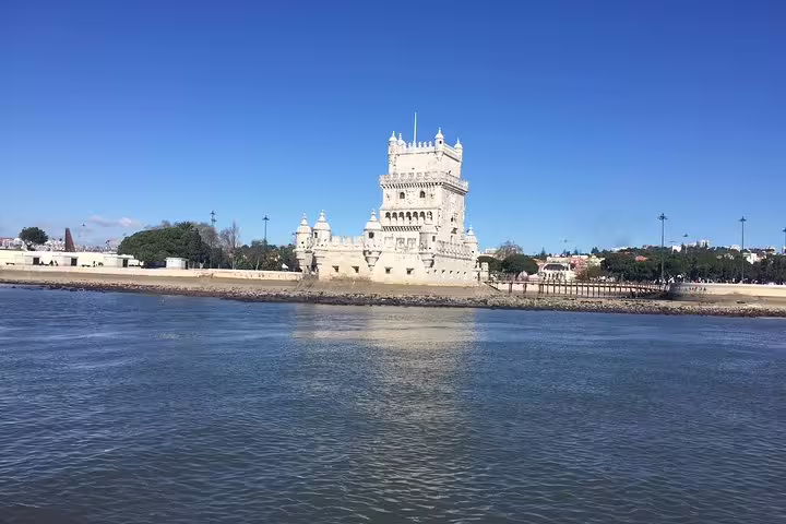 Belém Tower reflected in the Tagus River during a scenic morning sailing tour in Lisbon.