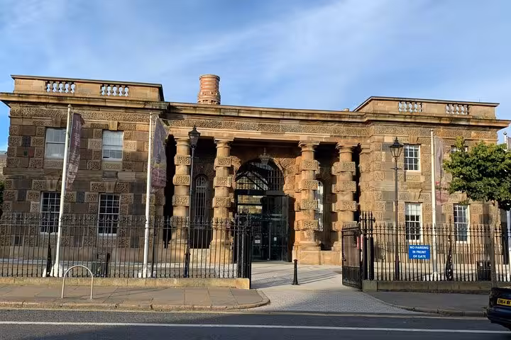 Historic sandstone building with iron gates in Belfast, a stop on the ghost walking tour