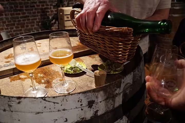 Belgian beer tasting in a Brussels cellar, pouring ale into glasses during a private Old City walking tour