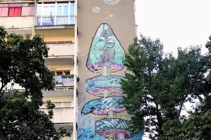 Colorful fishbone graffiti mural on Belgrade apartment block, stop on private street art walking tour