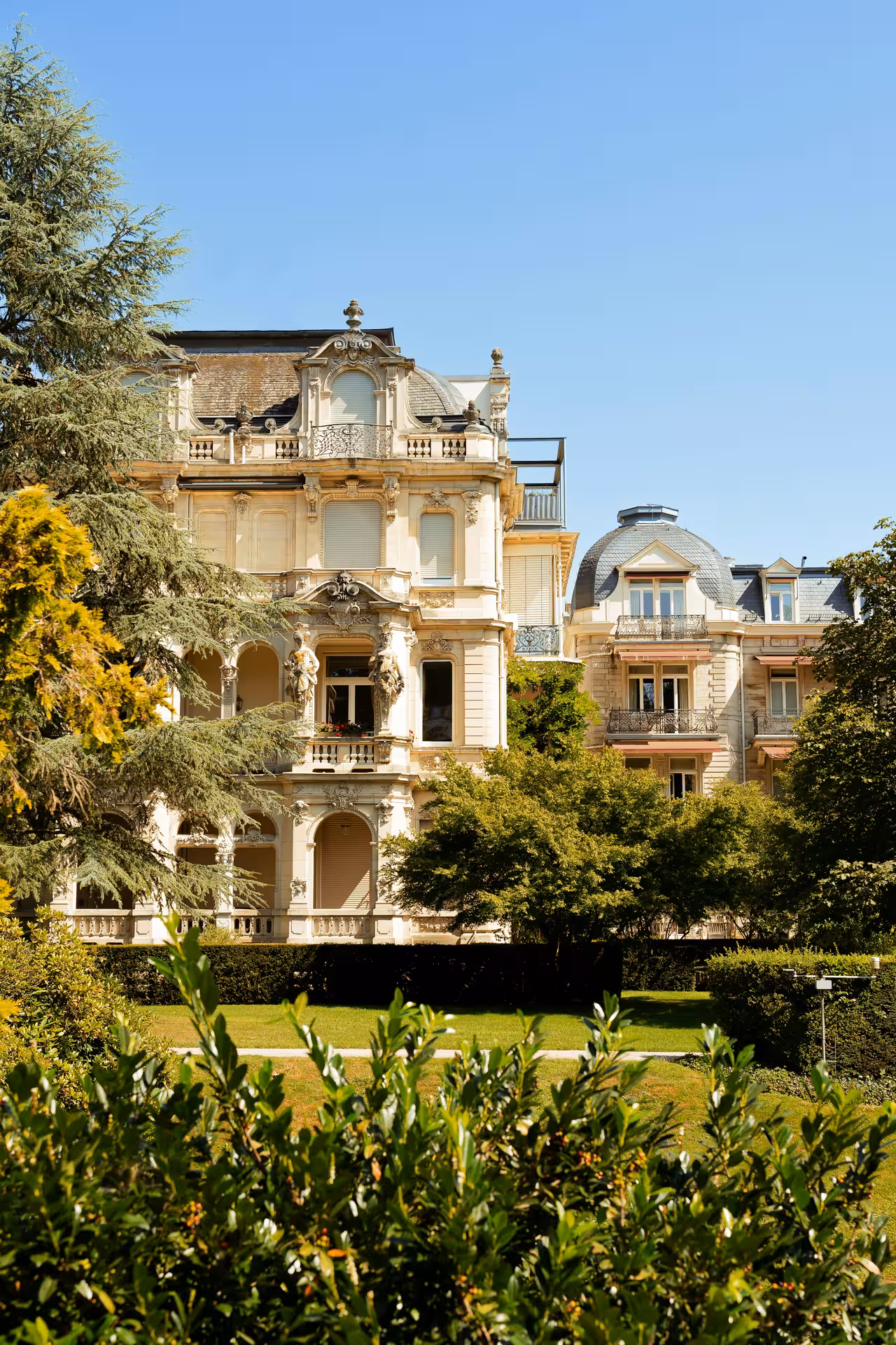 Ornate Belle Époque mansion facade with lush gardens in Baden-Baden, Germany