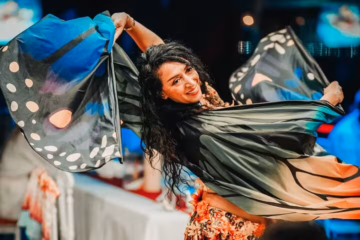 Belly dancer with colorful wings entertains guests on Istanbul New Year’s Eve party cruise on the Bosphorus