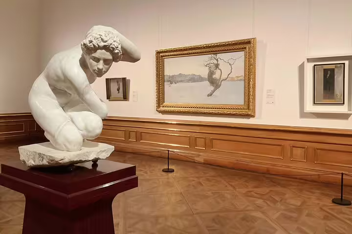Marble sculpture and framed paintings in the Belvedere, showcasing classical and modern art in Vienna.