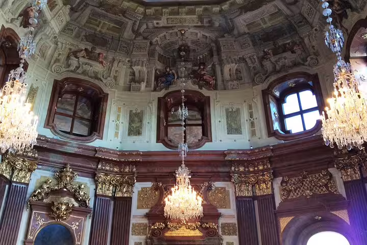 Ornate Baroque interior with chandeliers at Belvedere Palace, showcasing opulent design on a guided history tour.