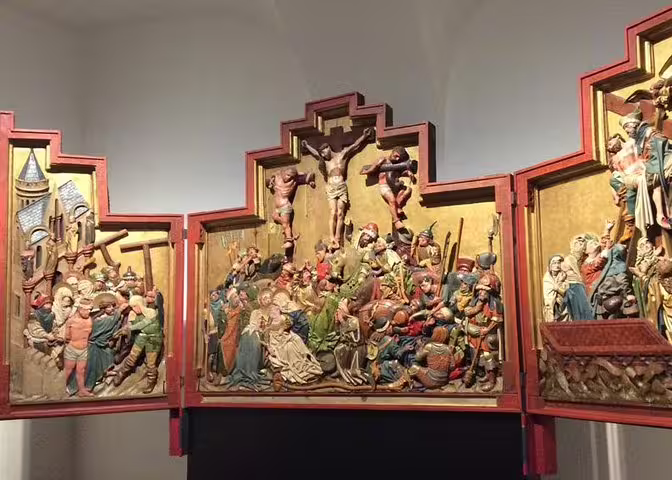 Detailed triptych sculpture illustrating biblical scenes, a highlight of the Belvedere Palace art history tour.
