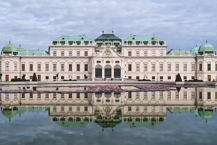 Elegant view of Belvedere Palace in Vienna reflected in a tranquil pond, showcasing stunning Baroque architecture on a private tour.