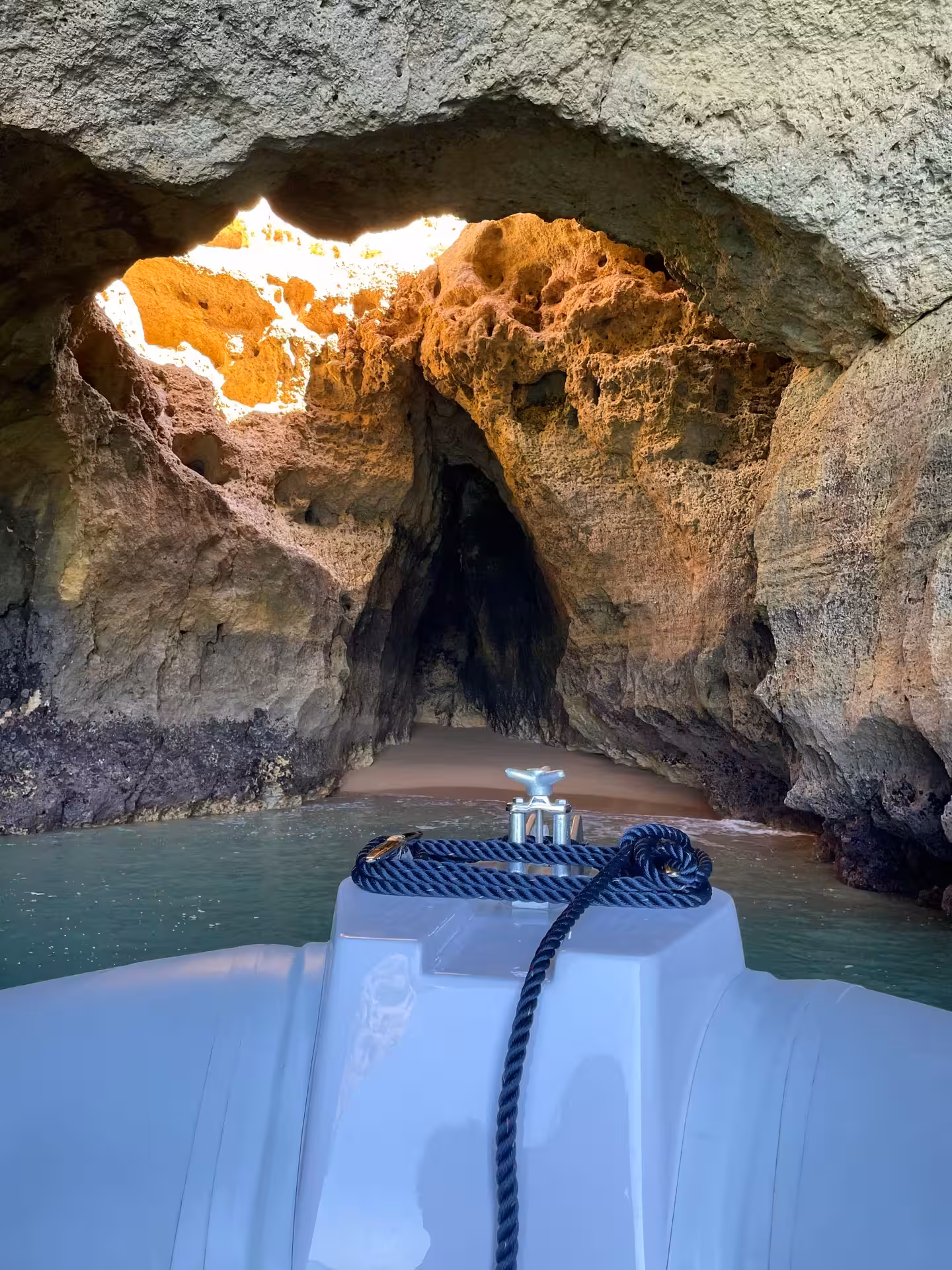 A boat approaches the enchanting entrance of Benagil Cave, revealing its unique rock formations and hidden beach.