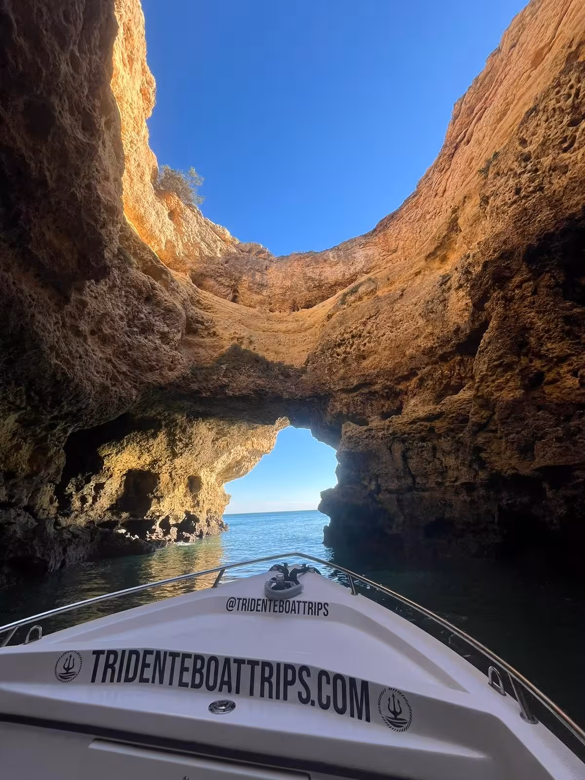 Small boat entering Benagil Cave through rocky archway on a private 2-hour Algarve coastal cruise in Portugal