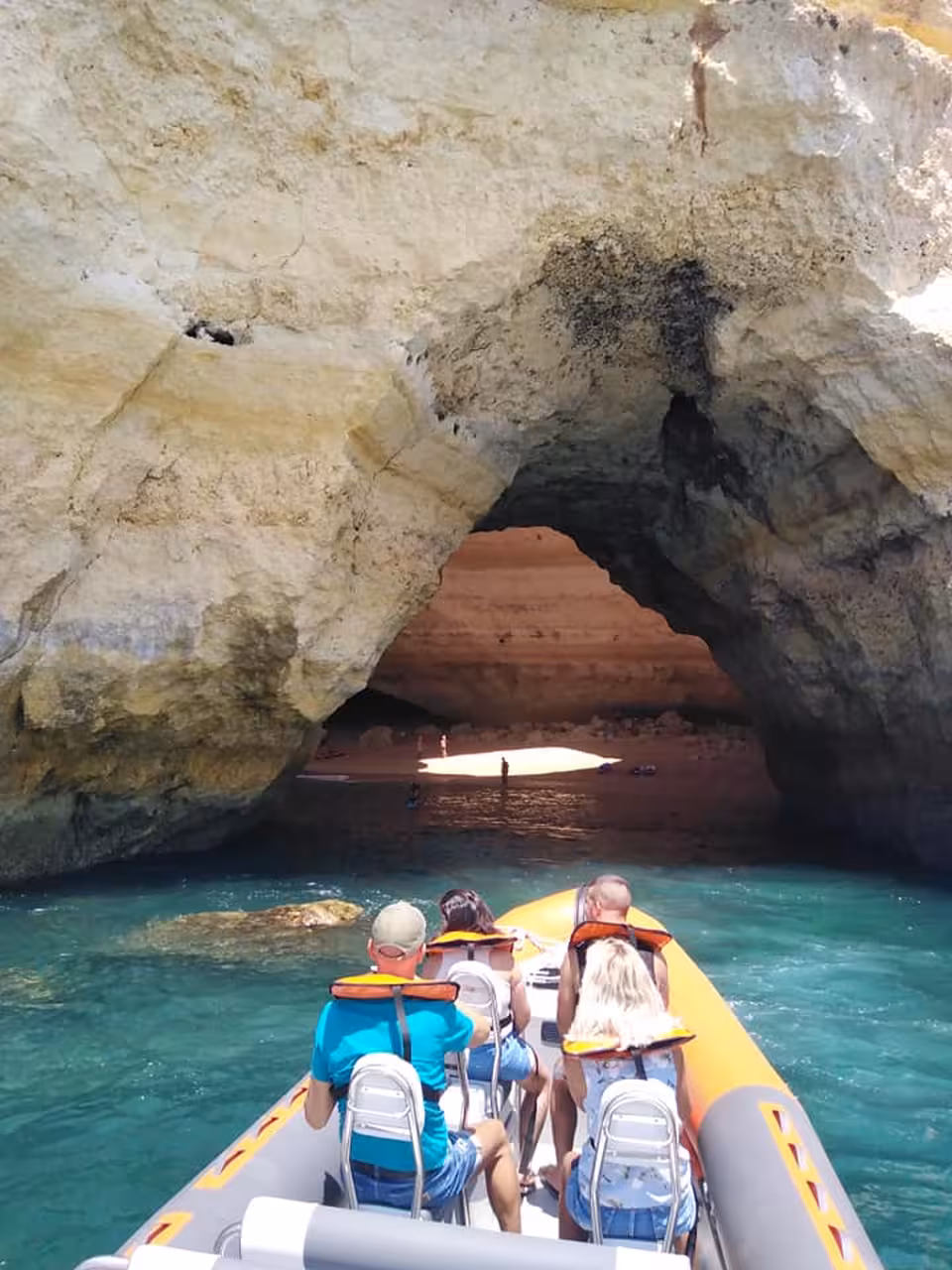 Private boat tour approaching the stunning Benagil sea cave entrance with turquoise waters along the Algarve coastline from Lagos