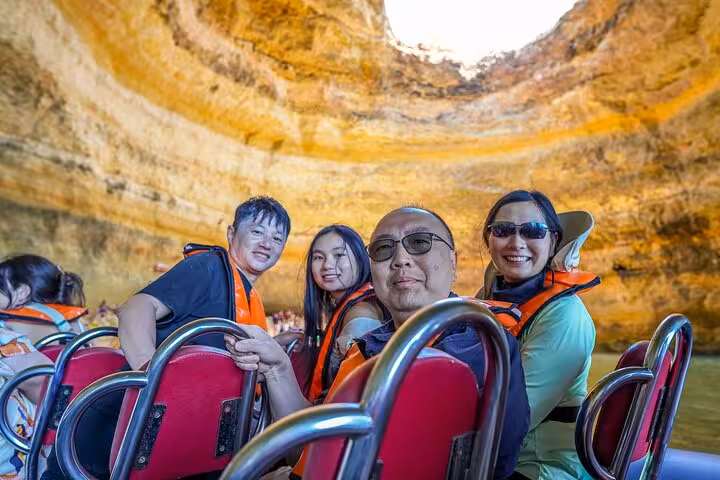 Benagil Cave boat tour from Lisbon to Algarve, travelers in life jackets inside the sea cave