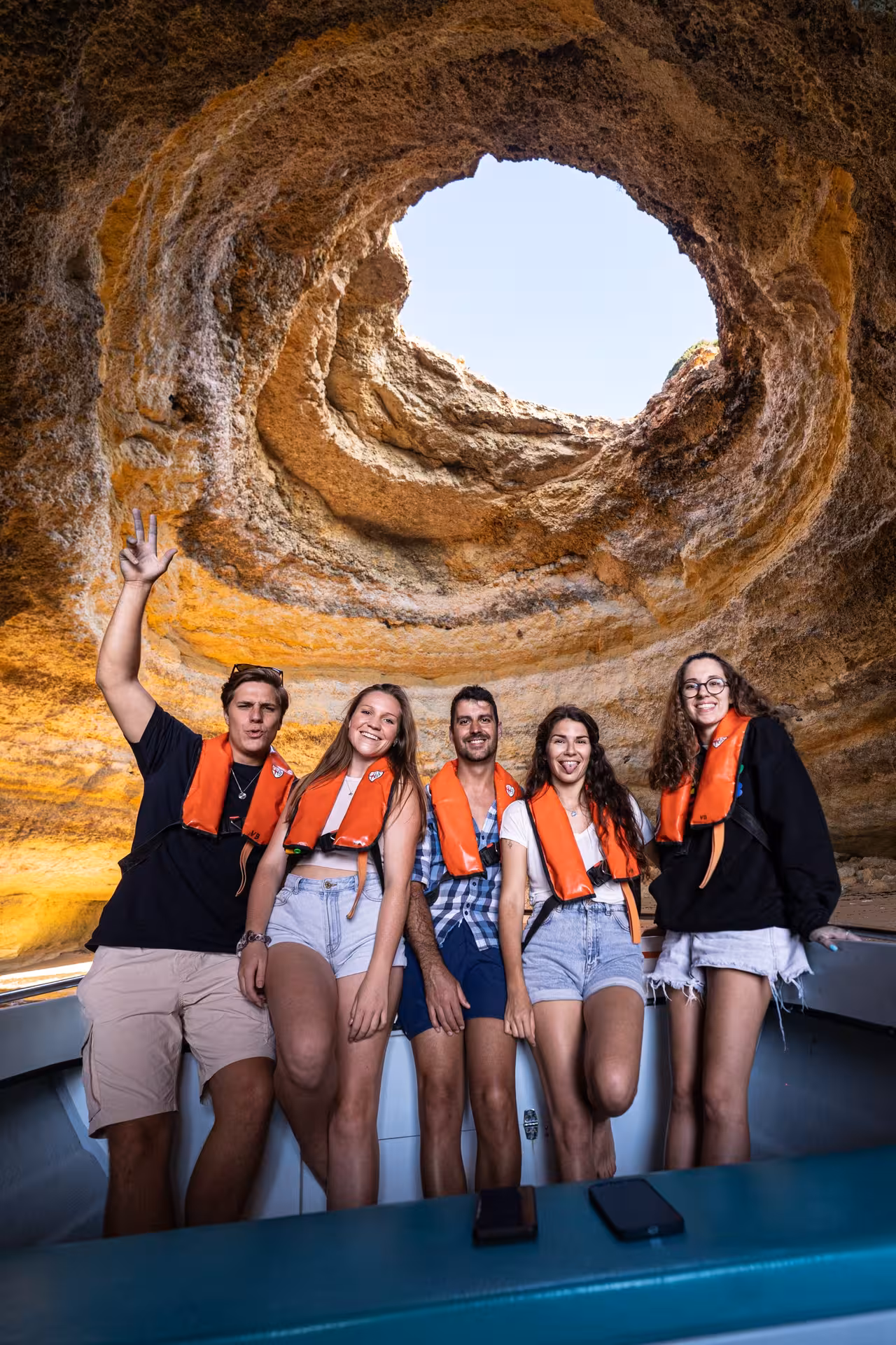 Group of friends inside the iconic Benagil Cave during a boat tour from Portimão, Algarve.