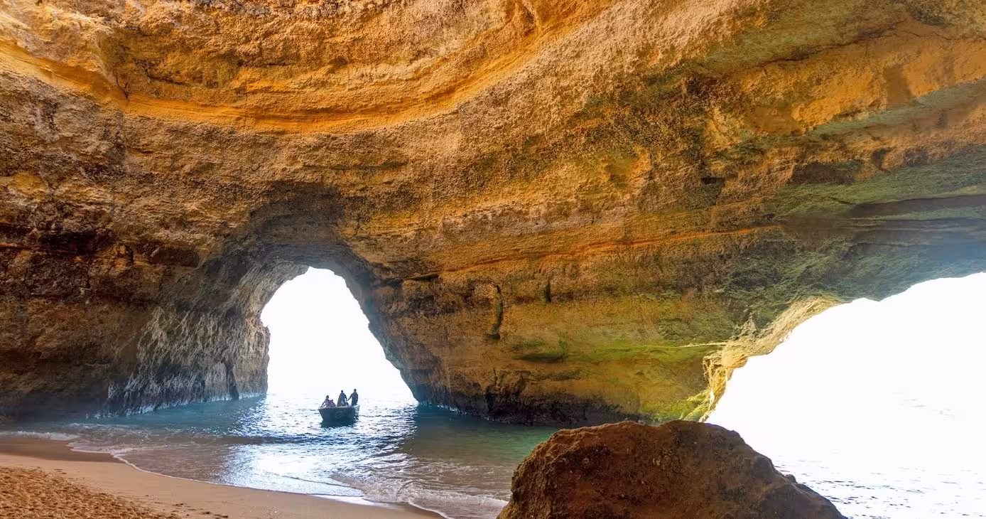 Boat with visitors enters the iconic Benagil Cave on a Classic Private Benagil 1H tour, revealing arches and hidden beach