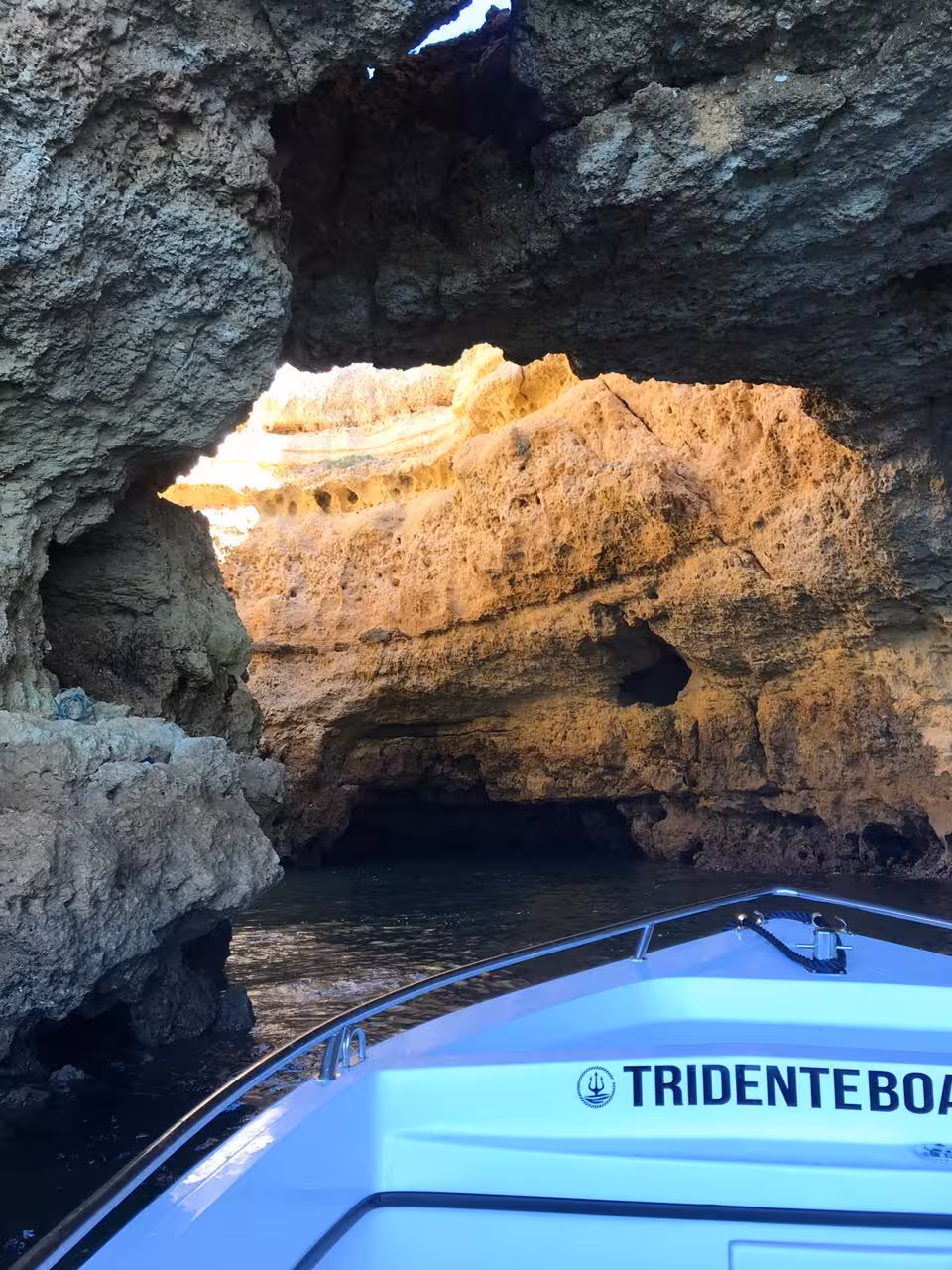 Private Benagil Cave deluxe boat tour entering stunning golden limestone sea cave with natural skylight opening in Algarve Portugal