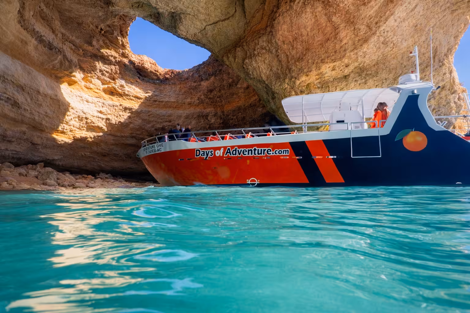 Days of Adventure boat cruising through the stunning turquoise waters of Benagil Cave on an Algarve full-day boat tour