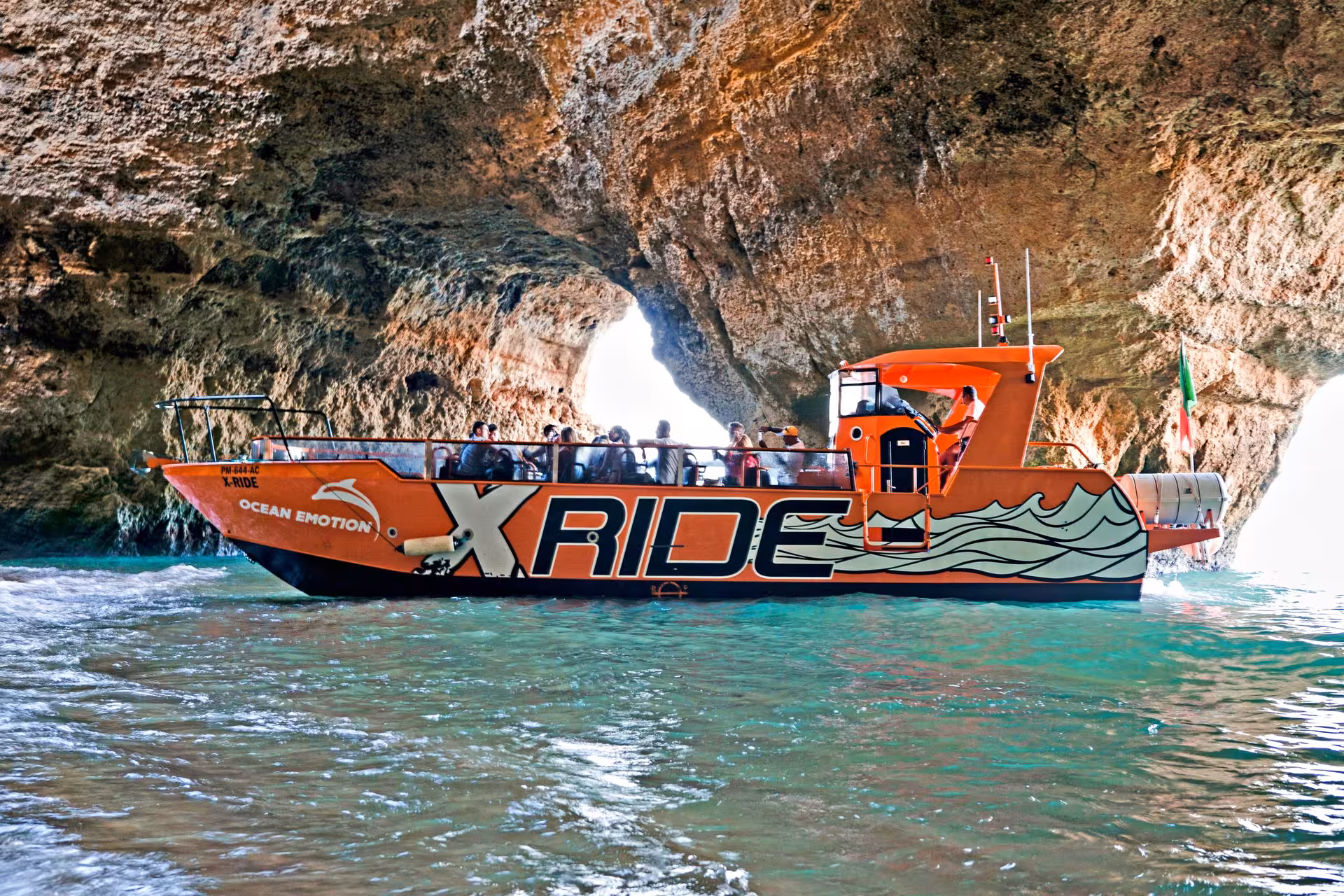 Tourists aboard the X Ride boat explore Benagil cave on an Algarve coast cruise, combining sea grottoes and dolphins