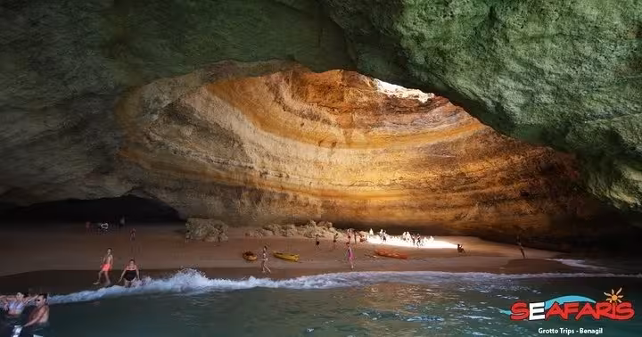 Tourists exploring the iconic Benagil Cave sea grotto on a guided boat trip from Lagos Algarve