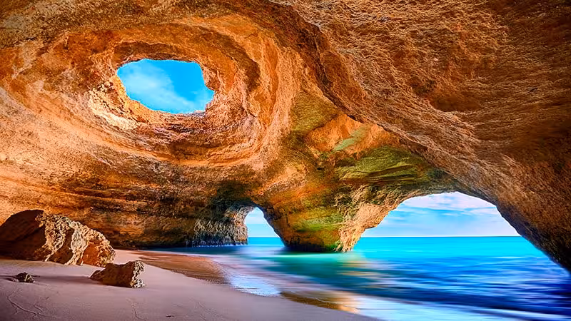 Stunning interior of Benagil Cave in Algarve Portugal with natural skylight and turquoise ocean waters on private kayak tour