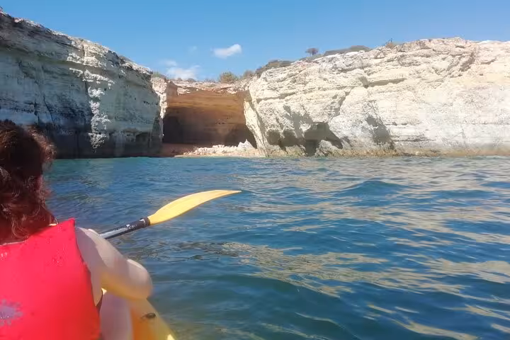 Kayaking to a hidden Algarve beach cove on a Benagil sea caves guided tour, with limestone cliffs ahead