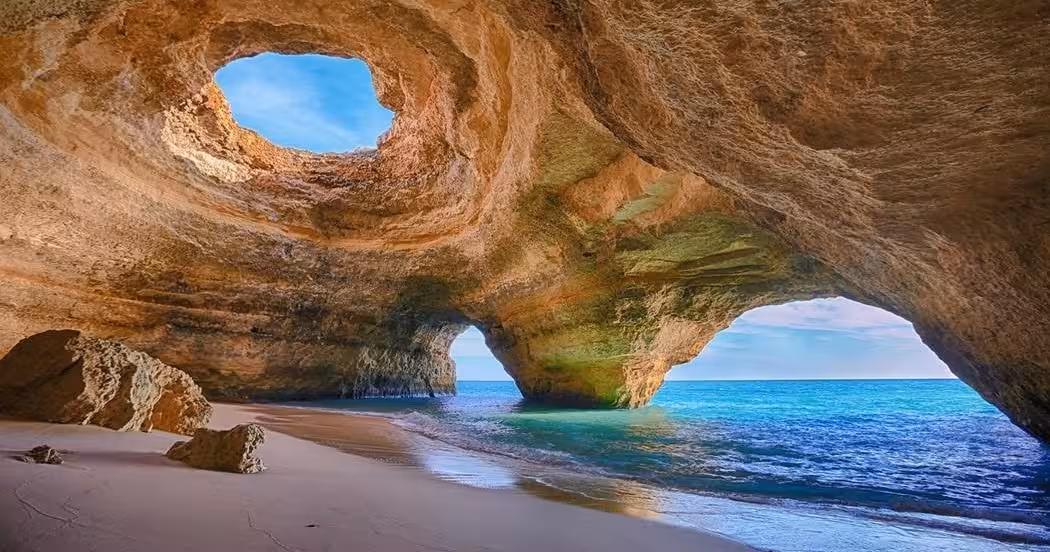 Scenic view of Benagil Sea Cave with turquoise Atlantic water, sandy beach and skylight, highlight of Algarve paddleboard tours