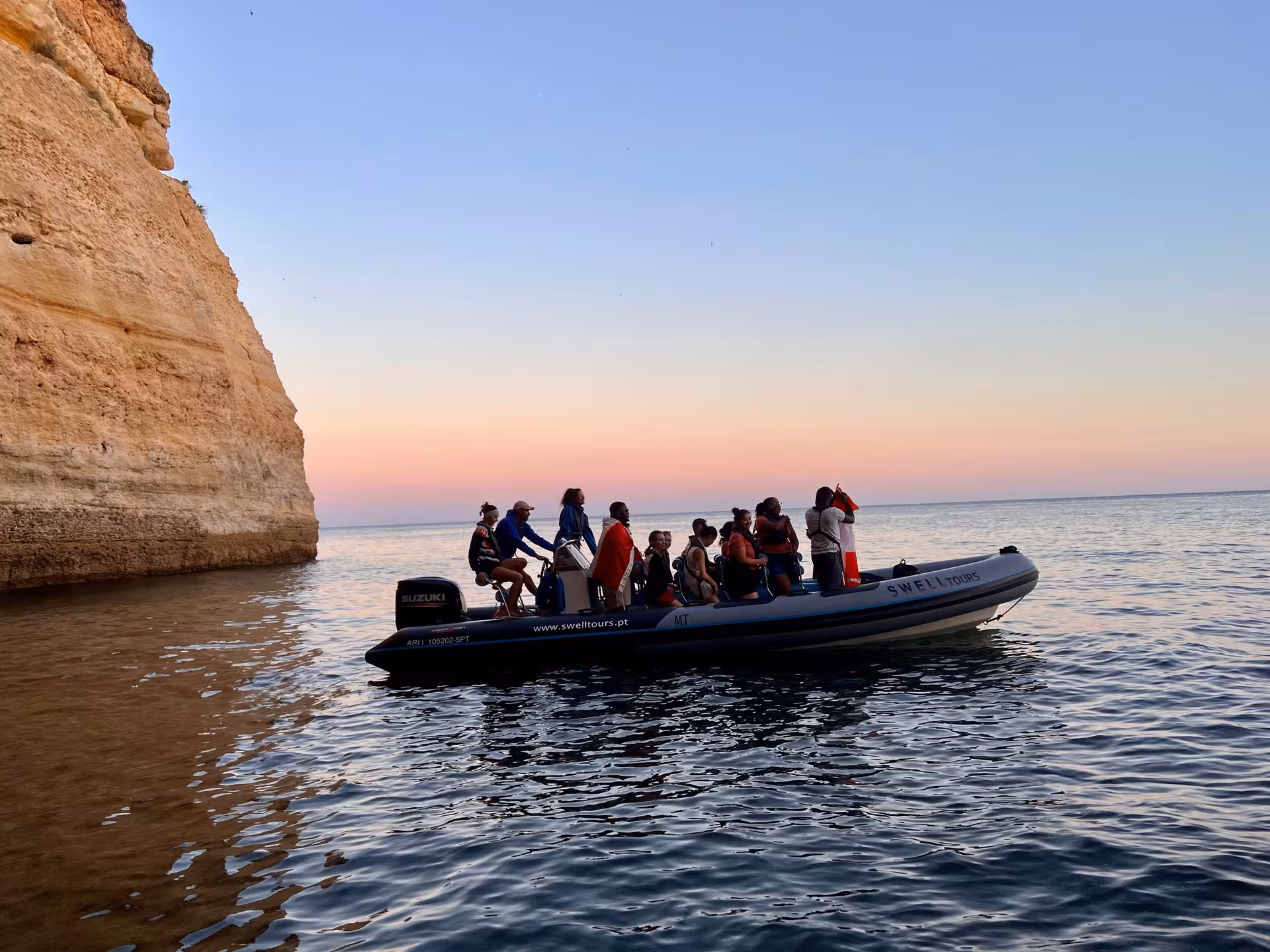 Explore coastal cliffs on a private boat tour at sunset, offering breathtaking views and exclusive adventure.
